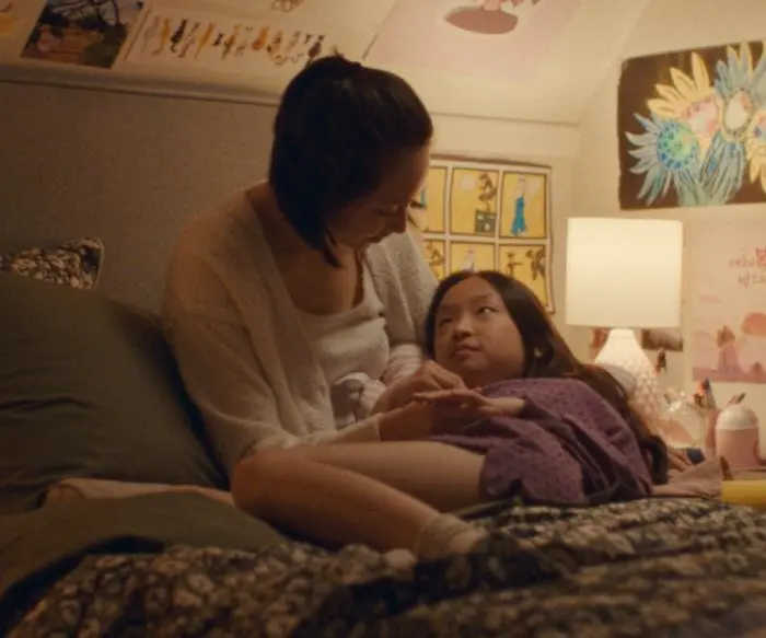 Asian American mother and daughter resting in bed