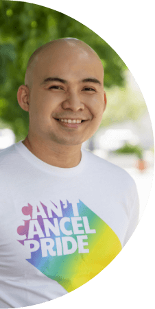 A man smiles while wearing a “Can’t Cancel Pride” t-shirt. 